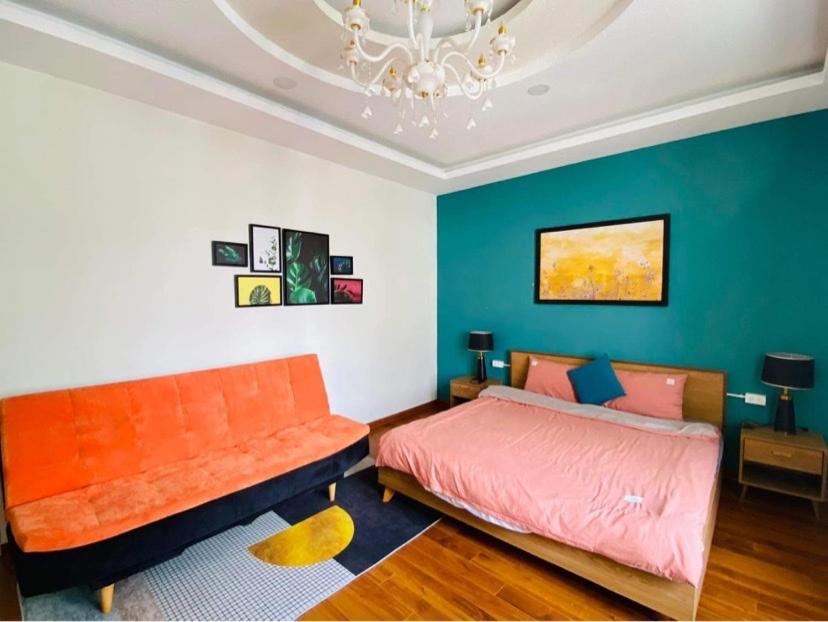 1 dormitorio con cama de color naranja y sofá en The Windy BnB 2 ,Villa nghỉ dưỡng lý tưởng, en Da Lat
