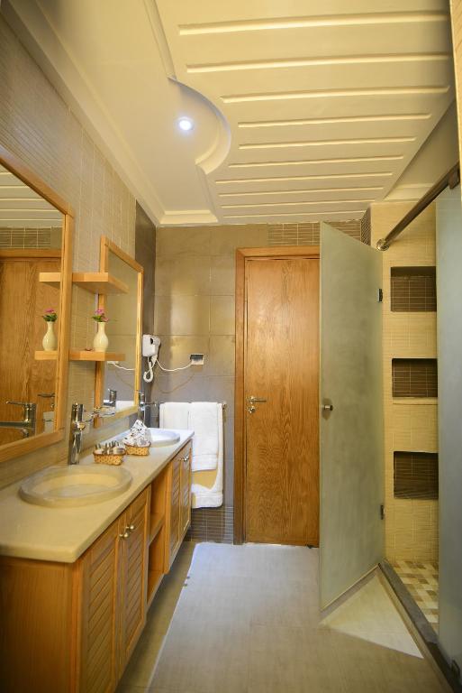 a bathroom with a sink and a toilet in it at Palm Djerba Suites in Mezraya