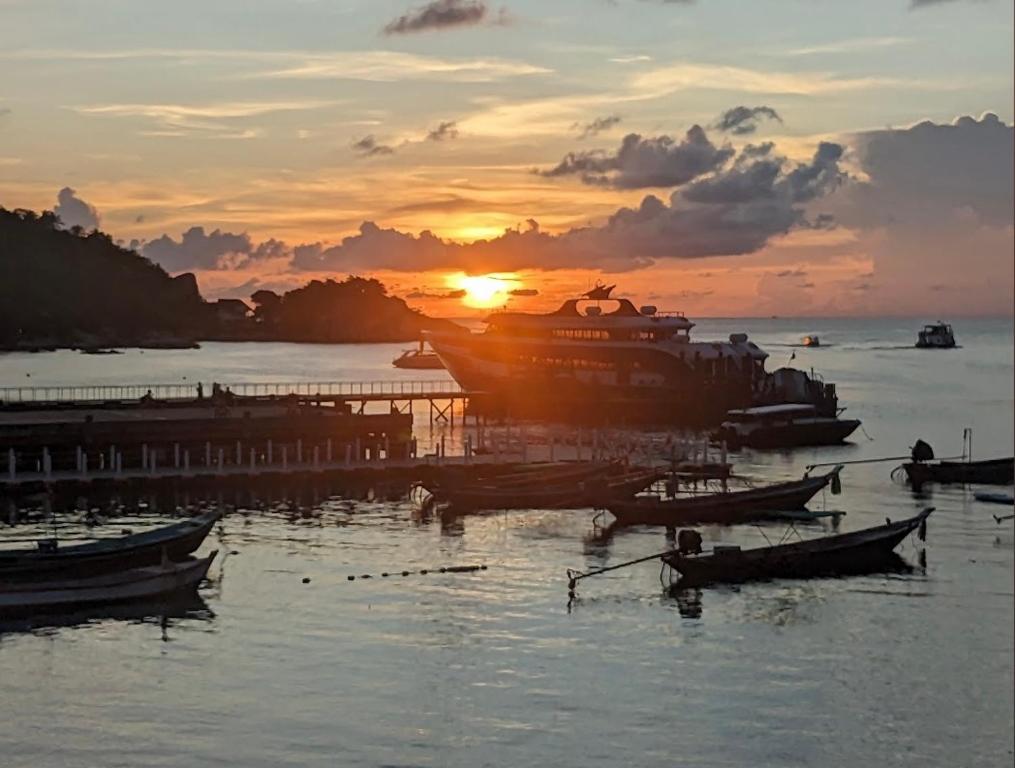 龜島的住宿－WaterMellow Hostel，日落时分在水中的小船