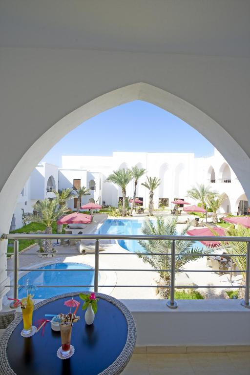 a view of the pool from the balcony of a resort at Palm Djerba Suites in Mezraya