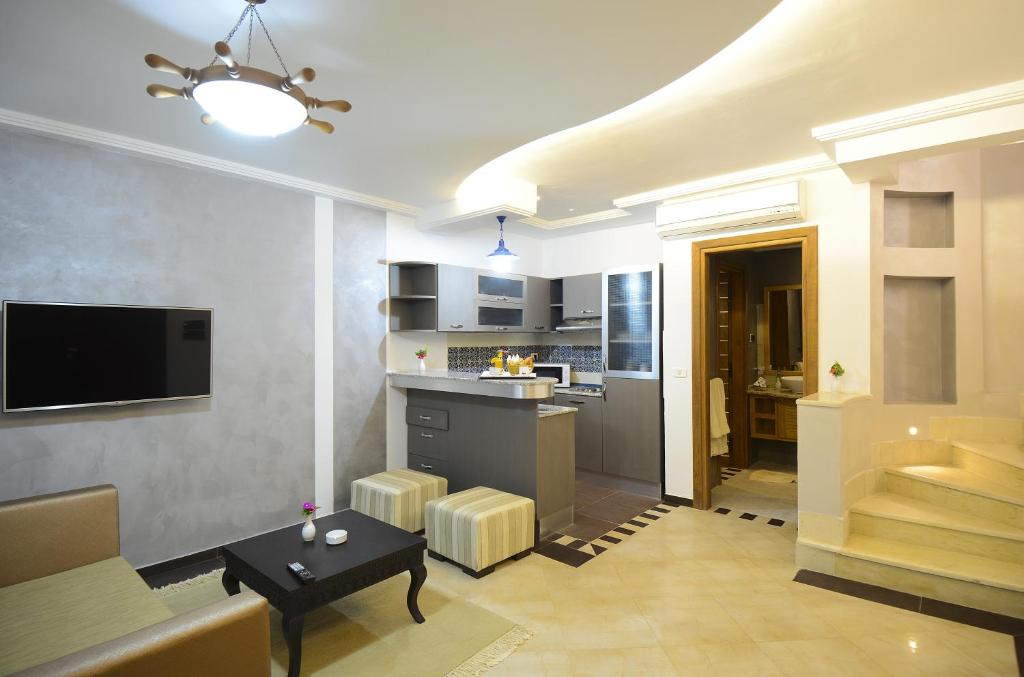 a living room with a couch and a table and a kitchen at Palm Djerba Suites in Mezraya