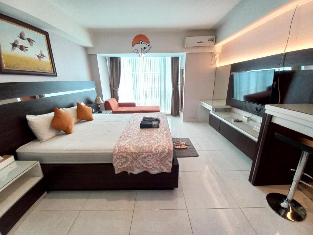 a bedroom with a large bed and a television at The Cabin Mataram City in Kejayan