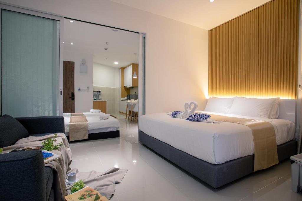 pokój hotelowy z 2 łóżkami i kanapą w obiekcie Just Chillin Pool & Seaview Suites w mieście Kota Kinabalu