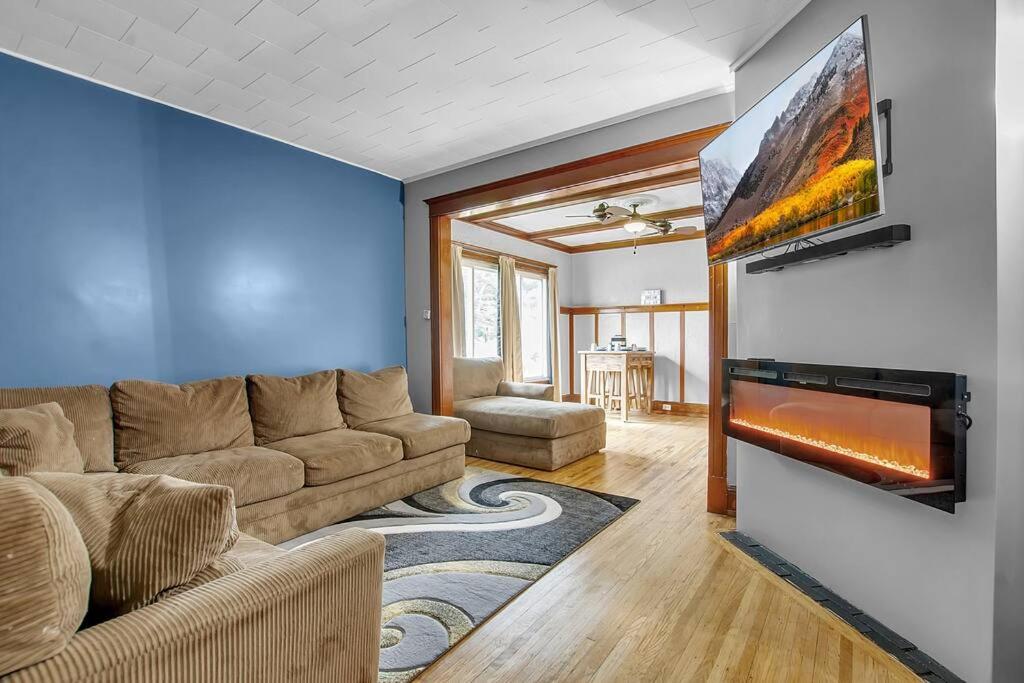 ein Wohnzimmer mit einem Sofa und einem Flachbild-TV in der Unterkunft Park Place Suites in Buffalo