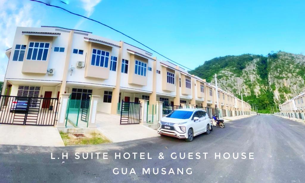 un coche aparcado frente a un hotel y una pensión en LH Homestay Suite Gua Musang- Masjid Mekah en Gua Musang
