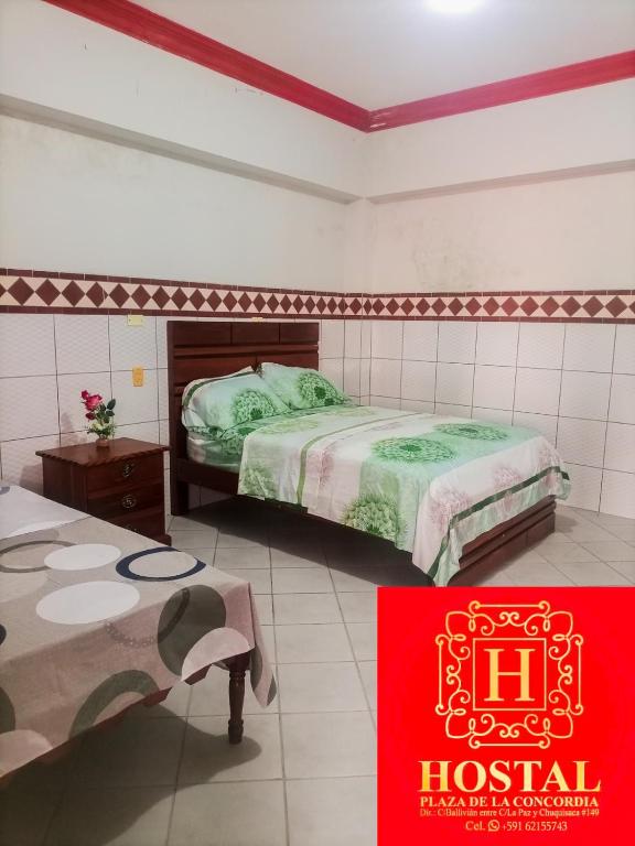 a hotel room with two beds and a red sign at Hostal Plaza de la Concordia in Santa Cruz de la Sierra