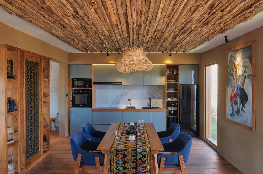 una sala da pranzo con tavolo e sedie blu di TUNAK Resort Lombok a Bumbang