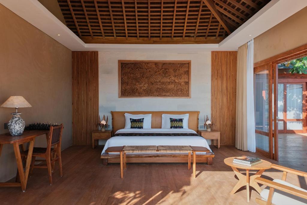 una camera con letto, tavolo e sedie di TUNAK Resort Lombok a Bumbang