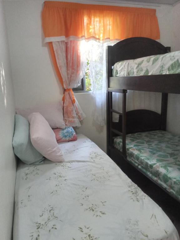 une chambre avec deux lits superposés et une fenêtre dans l'établissement Kitconforto, à Guarujá