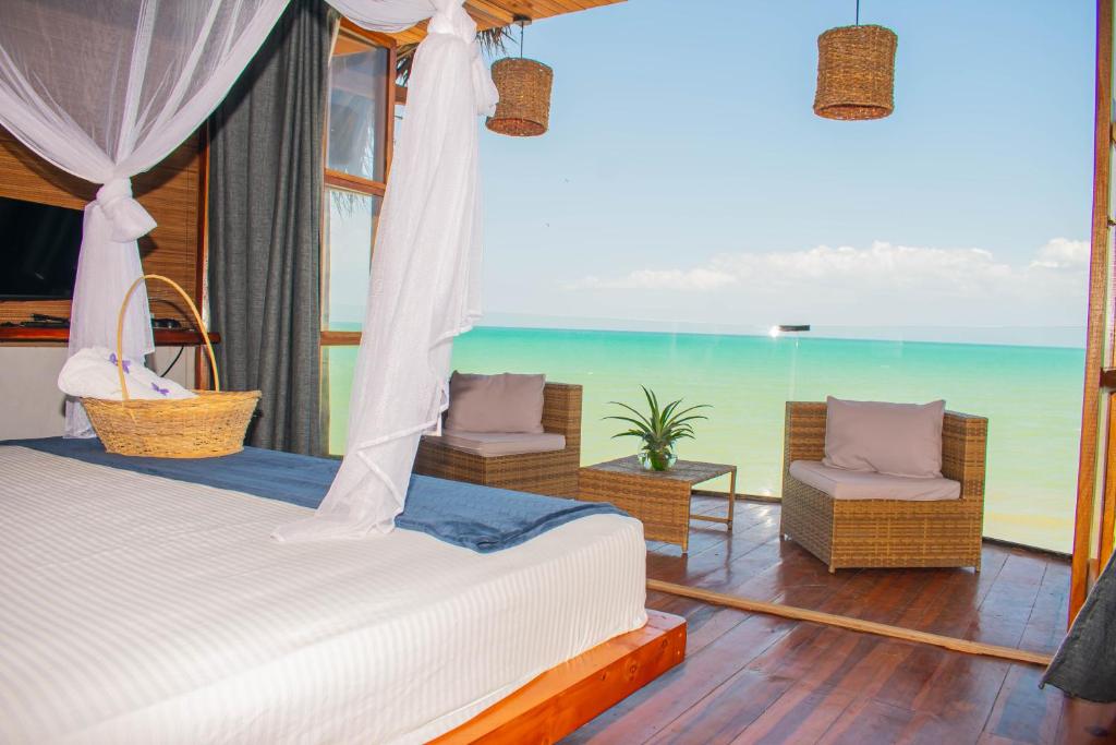 a bedroom with a bed and a view of the ocean at RCH LUXURY HOTEL & POOL in Dibulla