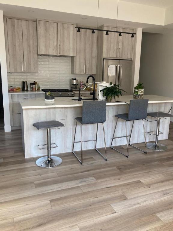 a kitchen with a counter and some chairs in it at Modern and cozy 4-Plex with a view! (1Bed, 1 Private Bathroom) in Kelowna