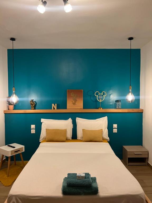 1 dormitorio con 1 cama grande y pared azul en DUPLEX 101 en Dzaoudzi