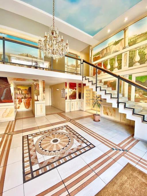 Cette grande chambre dispose d'un escalier et d'un lustre. dans l'établissement Appartement Canne 1 chambre - 52C, à Cannes