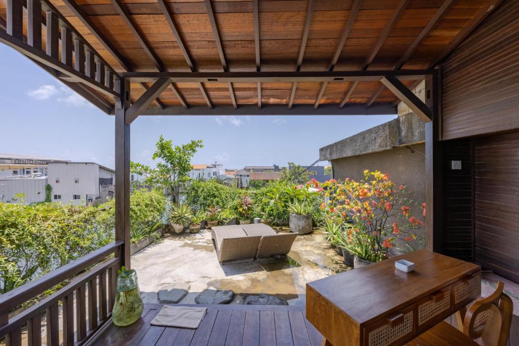 a patio with a couch and a table on a deck at Canggu Spirit Guest House in Canggu