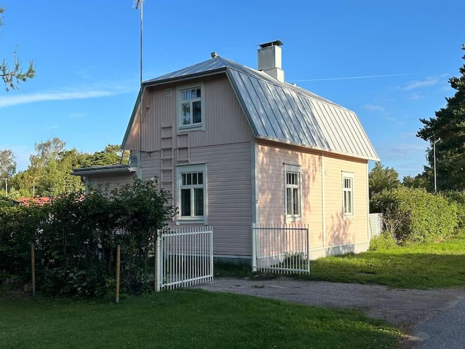 een klein huis met een hek ervoor bij Koko talo & piha ulkopore-altaalla in Hanko