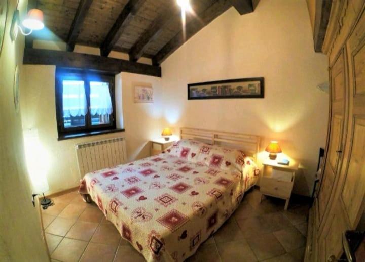 Un dormitorio con una cama grande y una ventana en Casa Le Petit Bijou, en Champoluc