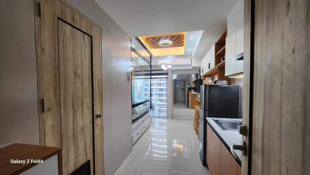 a hallway of a kitchen with a refrigerator and a microwave at CasaLaila in Davao City