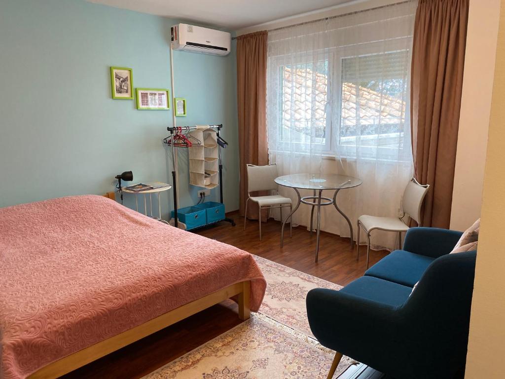 a bedroom with a bed and a table and a chair at Green Gate Apartments in Sarajevo