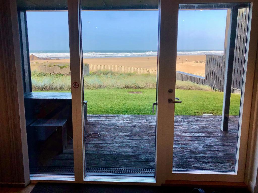 an open door with a view of the beach at Chapel Rock View, The Dunes in Perranporth