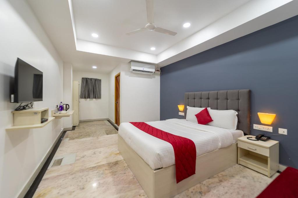 um quarto com uma cama grande e uma televisão em Seethala Bed & Breakfast em Pondicherry