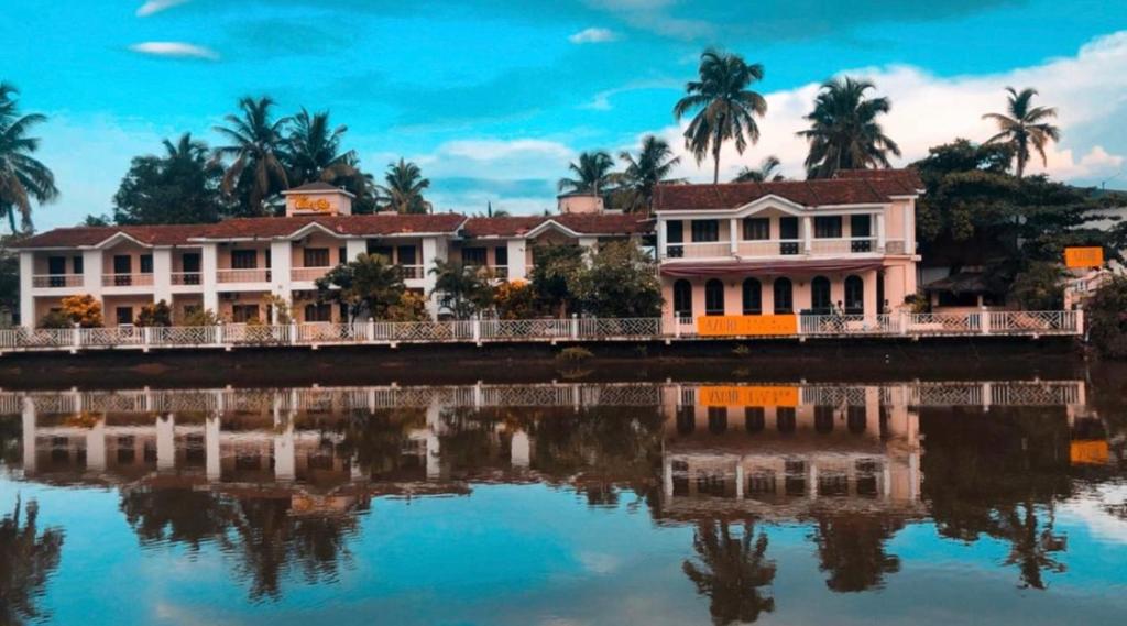 a house next to a body of water at Hotel Riverside in Baga