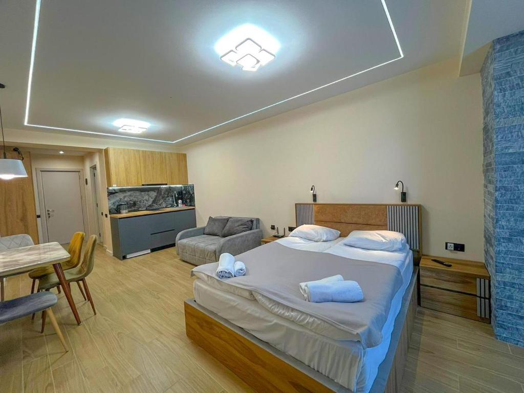 - une chambre avec un grand lit, une table et des chaises dans l'établissement New Gudauri F4, à Goudaouri