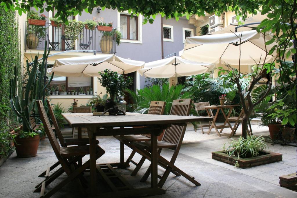 a table and chairs with umbrellas in a courtyard at Casa Barbero Charme B&B in Catania