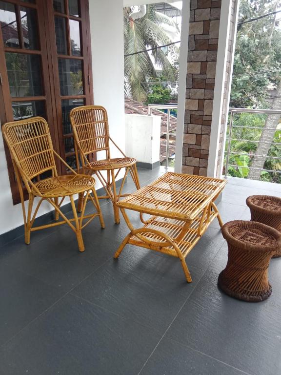twee stoelen en een tafel op een veranda bij Kochi Bella Villa in Cochin