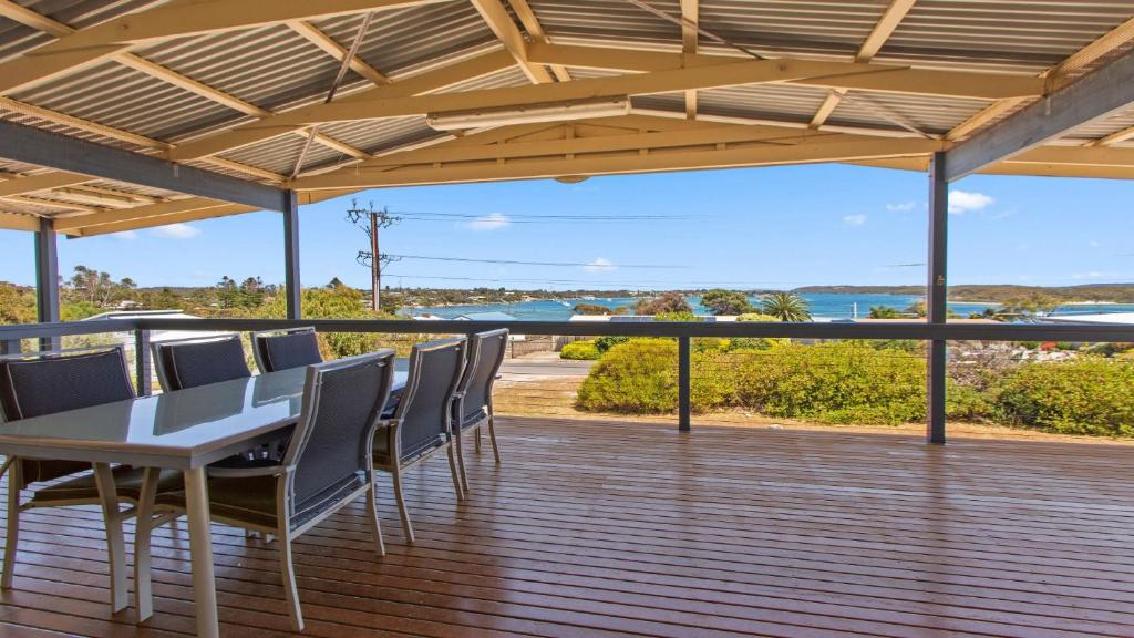 a patio with a table and chairs on a deck at Mariners View Coffin Bay in Coffin Bay