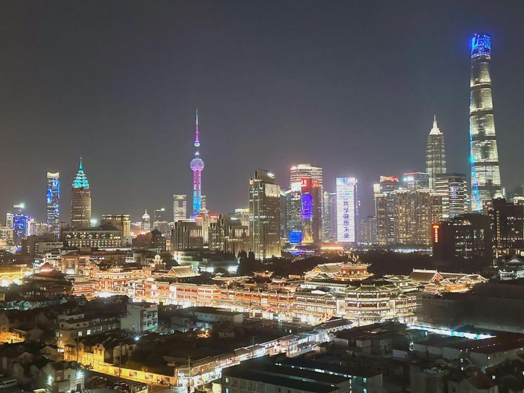 a lit up city at night with tall buildings at Sun Garden - Near the Bund in Shanghai