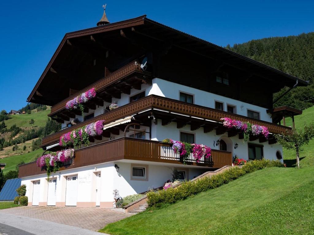 a building with flowers on the balconies on it at Cosy holiday flat in Pinzgau in Bramberg am Wildkogel