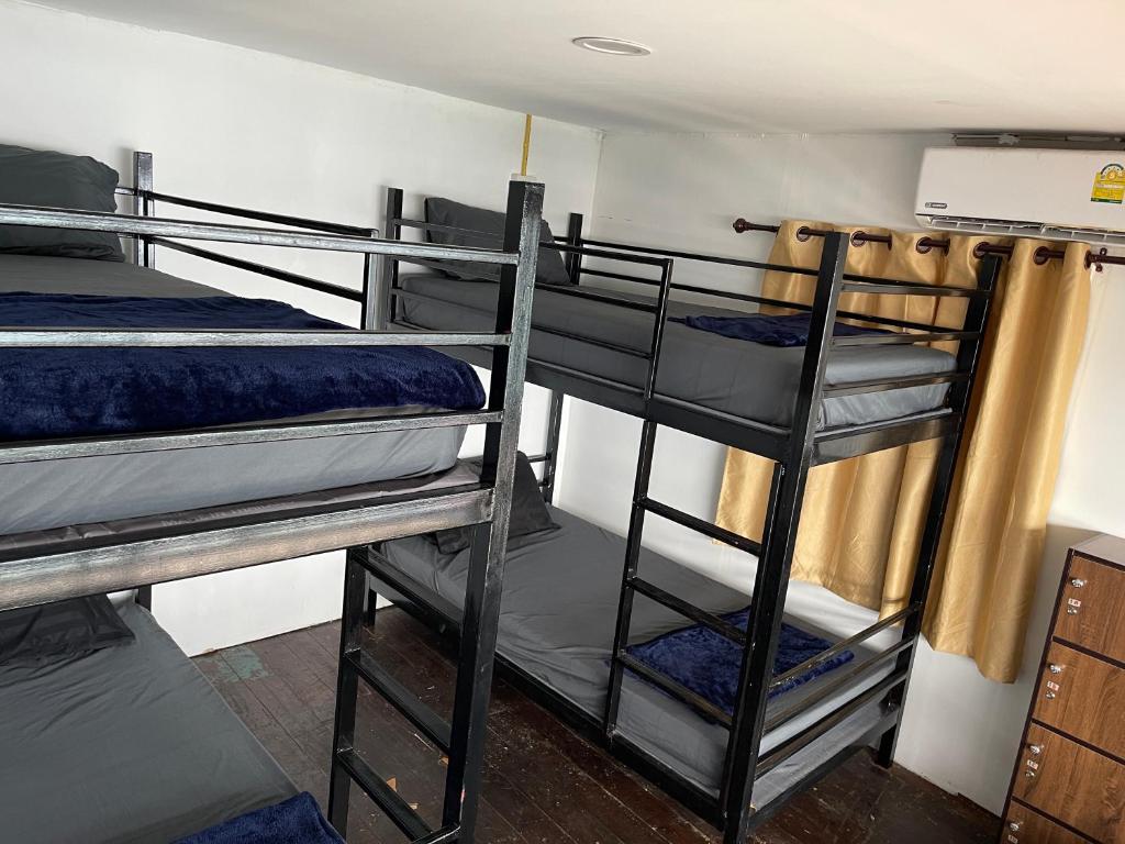a room with three bunk beds in a room at WaterMellow Hostel in Koh Tao