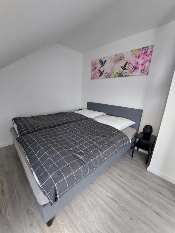 1 dormitorio con 1 cama en una habitación blanca en Ferienwohnung Uljana, en Schweich
