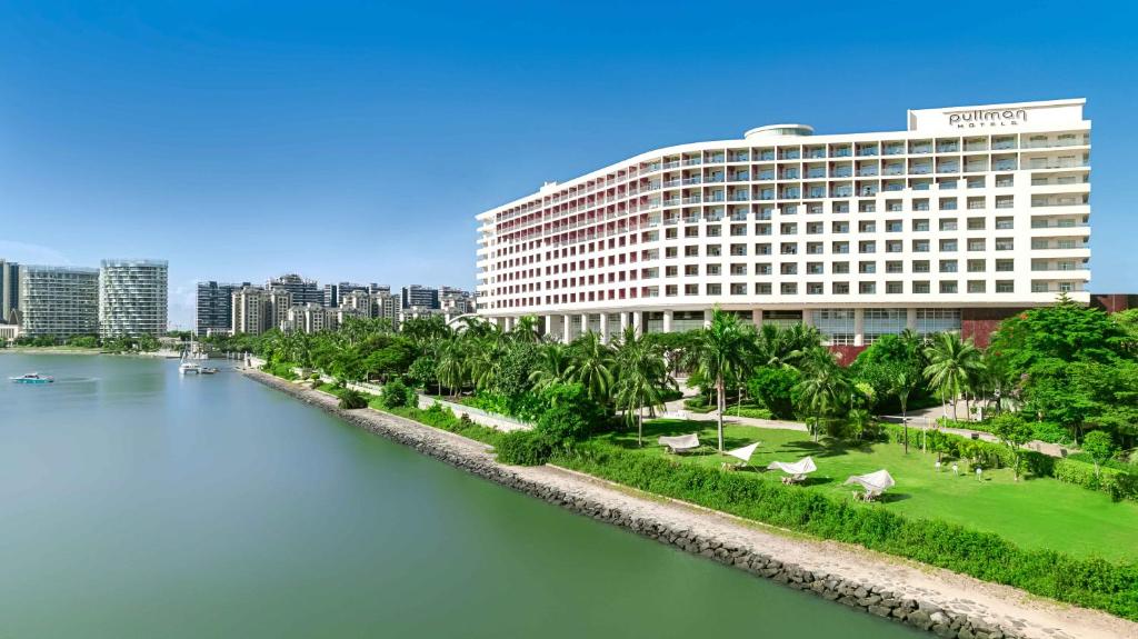 a large building next to a body of water at Pullman Haikou in Haikou
