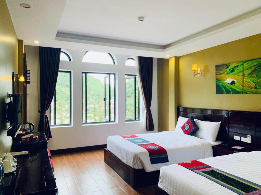a hotel room with two beds and two windows at Sapa Melody Hotel in Sa Pa