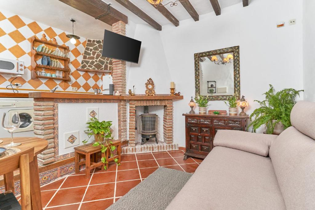 a living room with a couch and a fireplace at Casita Frigiliana in Frigiliana