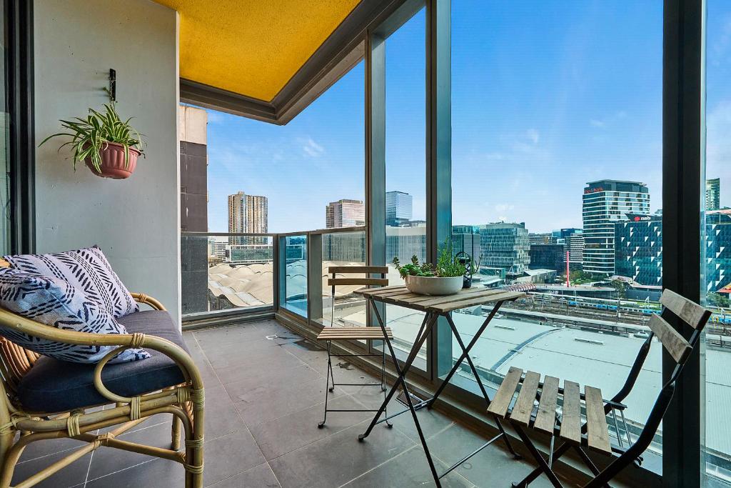 a balcony with a table and chairs and a view of the city at CBD Inner City Apartment in Melbourne