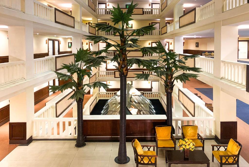 清邁的住宿－清邁皇家半島酒店，大堂设有两棵棕榈树和椅子