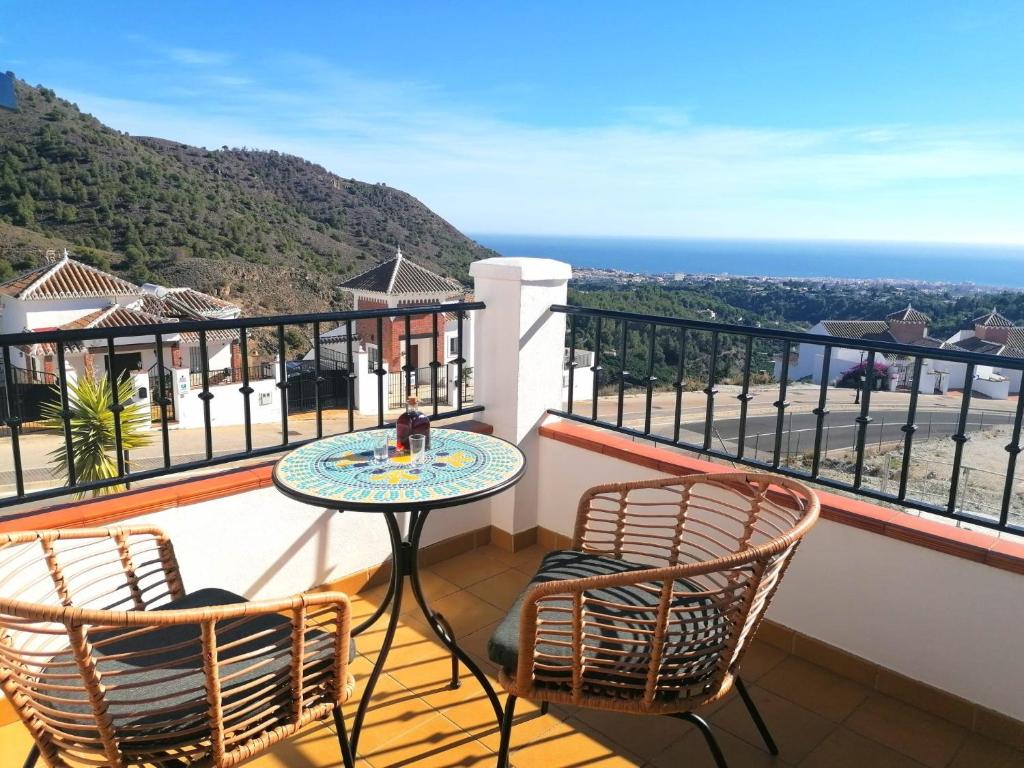 balcón con mesa, sillas y vistas al océano en CASA DIEGO PUERTO BLANQUILLO, en Frigiliana