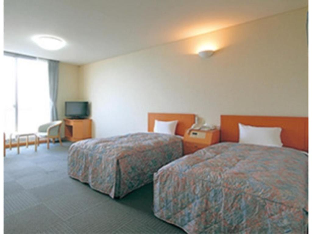 Habitación de hotel con 2 camas y TV en Kaikyo View SHIMONOSEKI - Vacation STAY 13687v, en Shimonoseki
