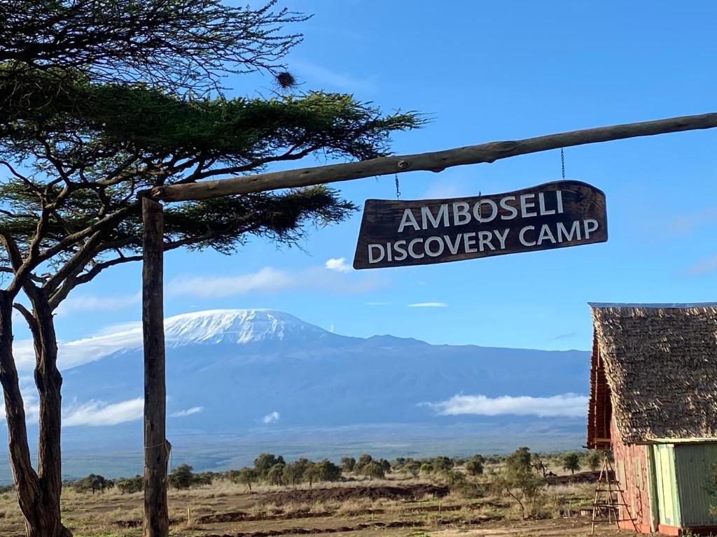 un panneau indiquant le camp de découverte de l'ambassade avec une montagne en arrière-plan dans l'établissement Amboseli Discovery Camp, à Amboseli