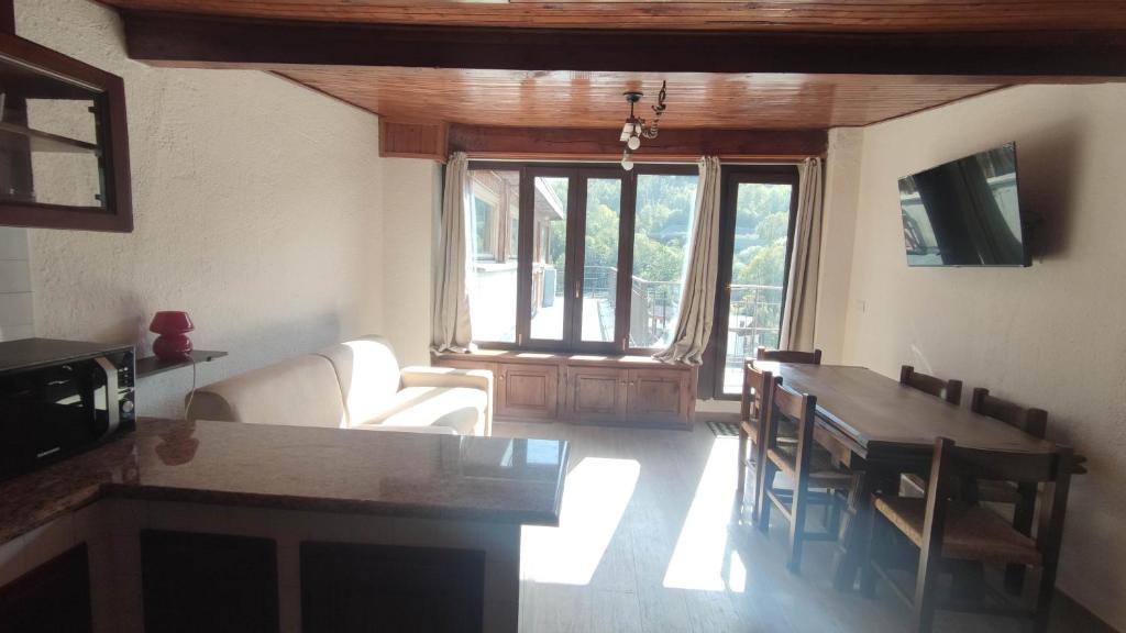 a living room with a couch and a dining room table at Mansarda con vista panoramica Limone Piemonte in Limone Piemonte