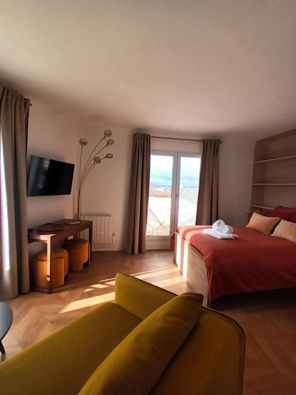 une chambre d'hôtel avec un lit, un canapé et une fenêtre dans l'établissement PARIS Balcony TOP FLOOR Room, à Paris