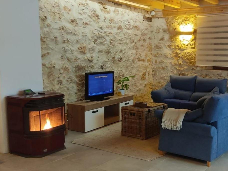 un soggiorno con divano, TV e camino di Montelobos 