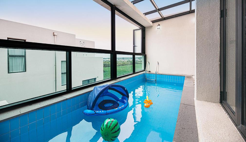 済州市にあるHomechee Kids Poolvillaのブルーボート付きのスイミングプール