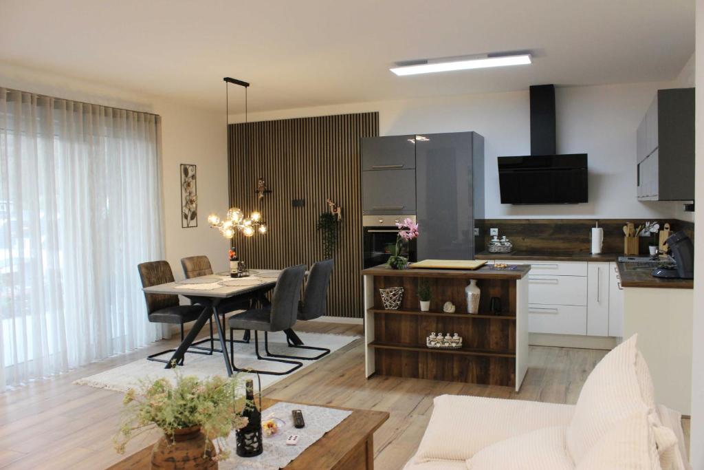 ein Wohnzimmer und eine Küche mit einem Tisch und Stühlen in der Unterkunft Wiedbachtaljuwel in Roßbach