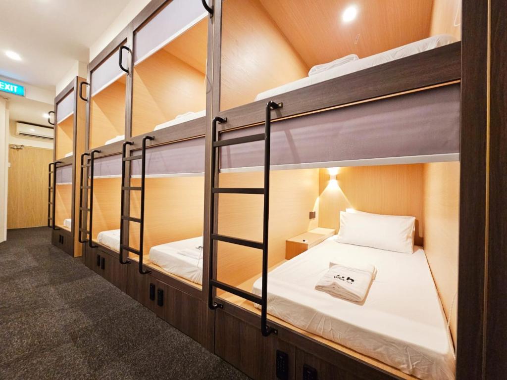 a room with four bunk beds in a building at Wink at Perak Road in Singapore
