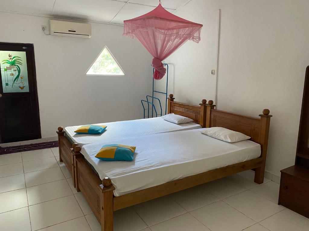 a bedroom with a bed with a pink umbrella at Sunflower Inn in Dambulla