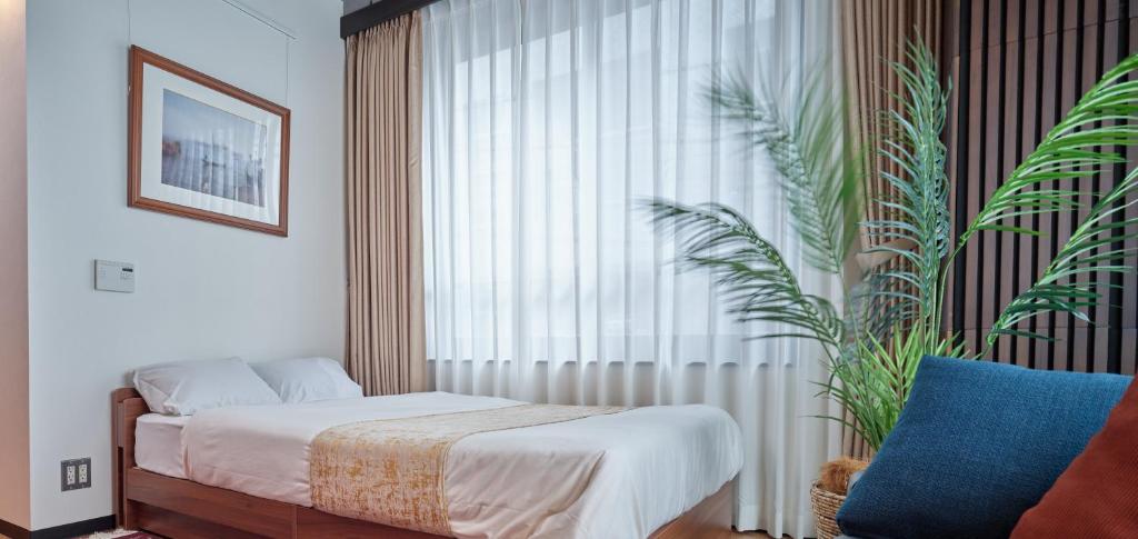 a bedroom with a bed and a large window at Acoustic GARAGE by Tranova in Tokyo