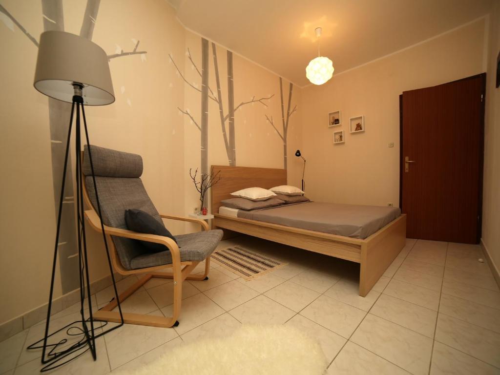 um quarto com uma cama, uma cadeira e um candeeiro em Dandelion Apartment - free parking em Fažana
